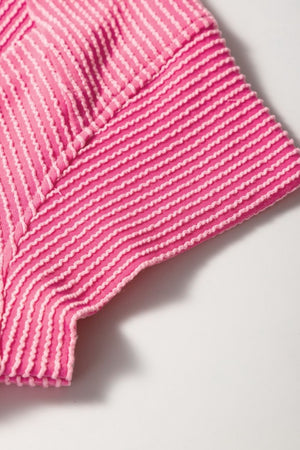 Fuchsia pink ribbed knit co-ord set detail showing textured stripes and stitching.