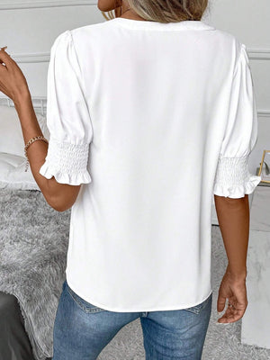 White shirred sleeve blouse with ruffle cuffs and a plunge neckline.