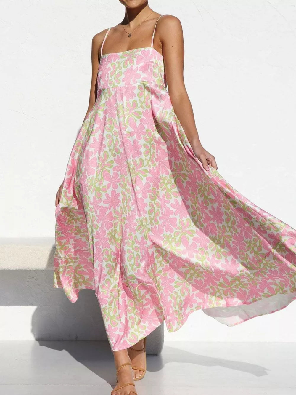Maxi dress with spaghetti straps and a pink and green floral print.