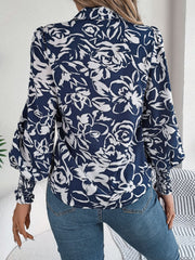 Navy floral print blouse with shirred cuffs and puff sleeves.