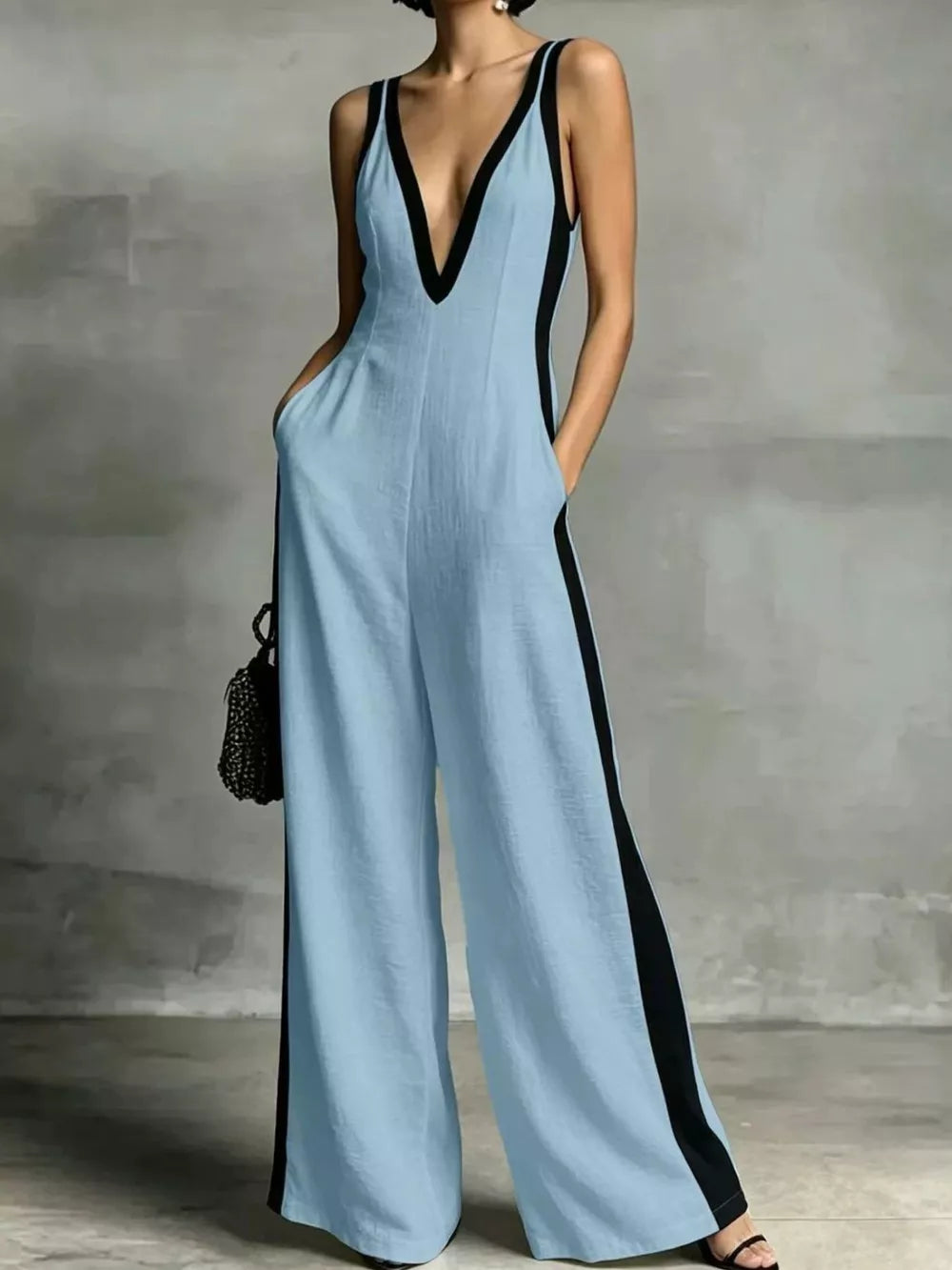Light blue wide-leg jumpsuit with deep V-neck and black contrast trim.
