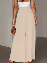 Beige wide-leg trousers with paperbag waist and a white tank top.