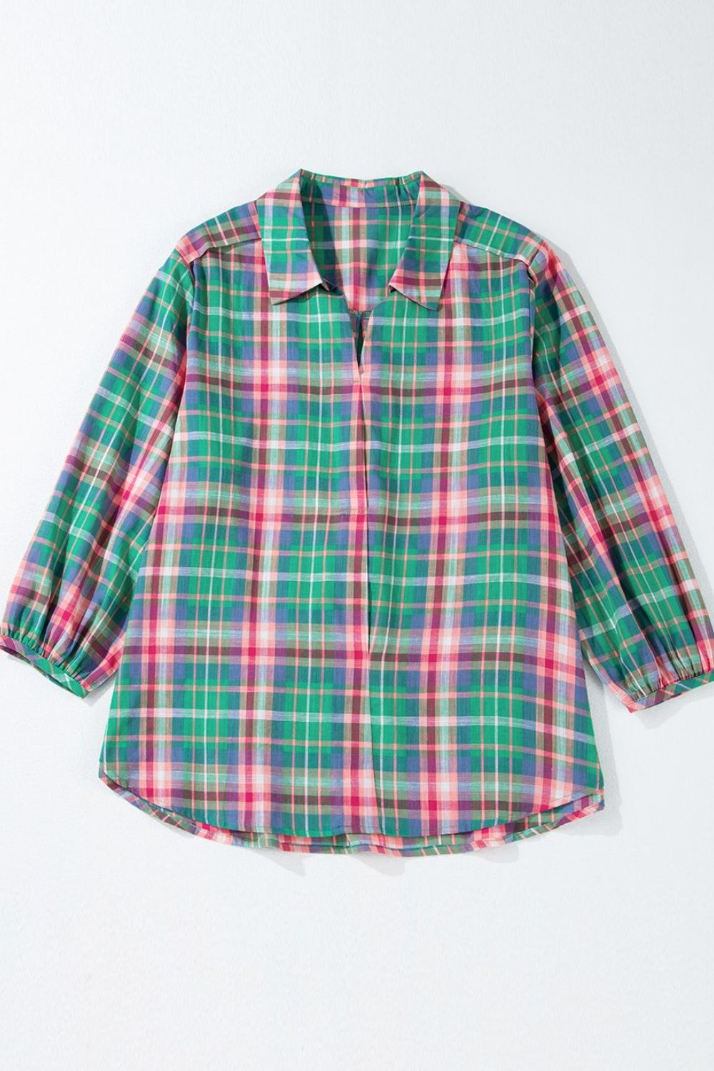 Voluminous plaid blouse with gathered sleeves and a V-neck.