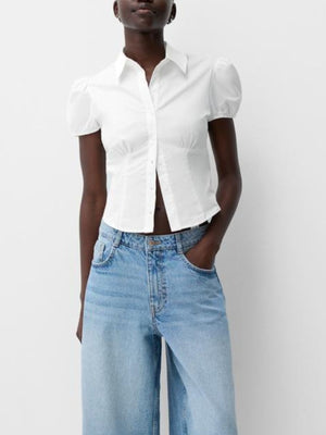 White maternity shirt with puff sleeves, gathered waist, and button-up front.