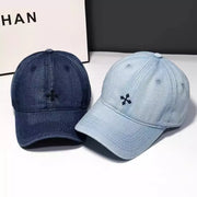 Embroidered denim baseball hats in dark blue and light blue with a small black cross detail.
