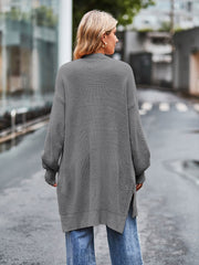 Open-stitch waffle knit duster cardigan in grey with side slits and open knit sleeves.
