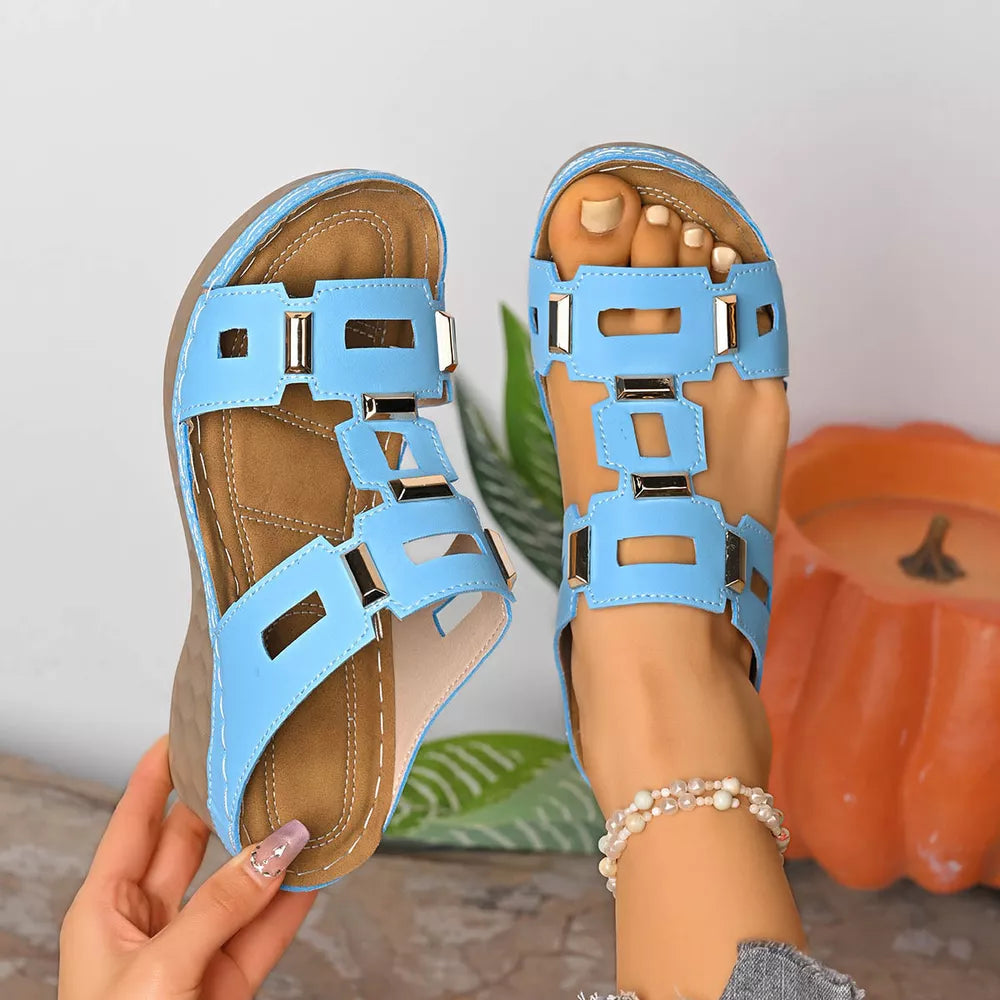Sky blue open-toe wedge sandals with cut-out straps and gold accents.
