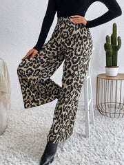 Leopard print palazzo trousers with a high waist and wide leg, styled with a black top and boots.