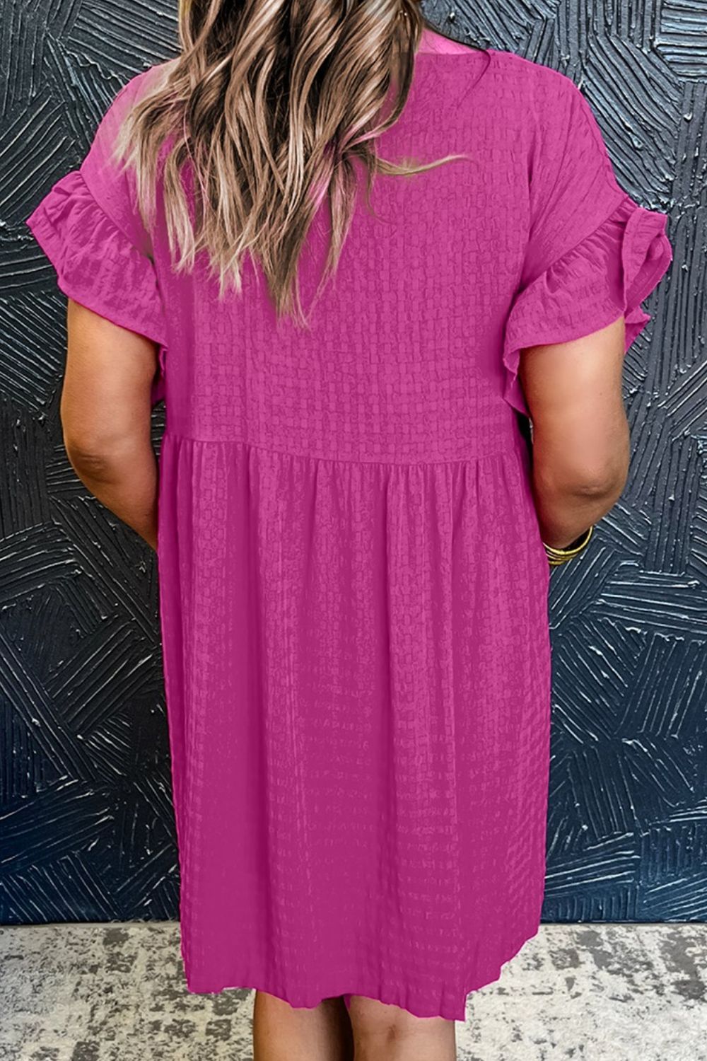 Hot pink textured babydoll dress with ruffle sleeves and a gathered waist.