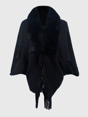 Black textured knit poncho with faux fur collar and fringe detail