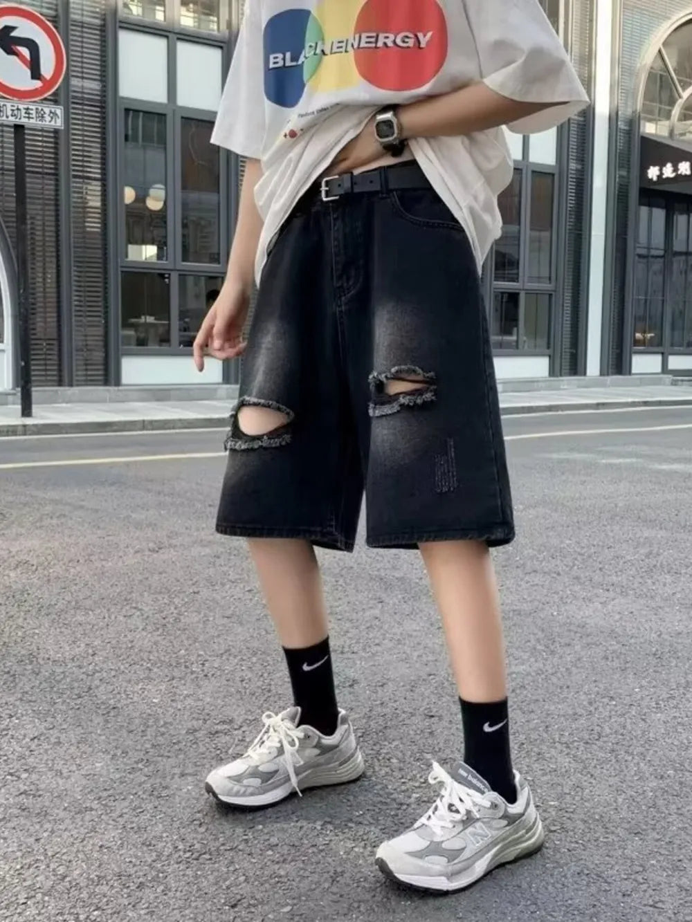 Black relaxed fit denim shorts with distressed rips and a baggy cut.