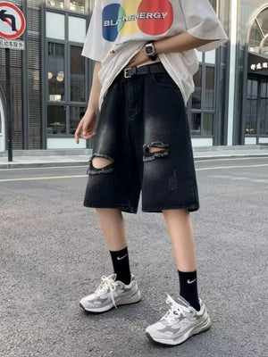 Black relaxed fit denim shorts with distressed rips and a baggy cut.