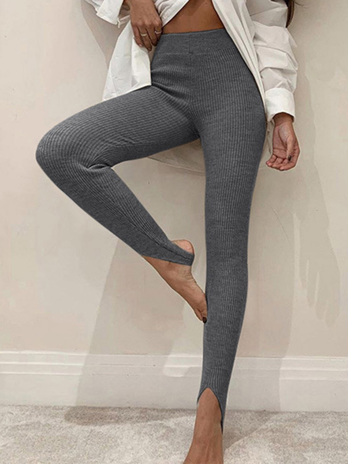 Charcoal ribbed knit stirrup leggings with a high waist and split hem.