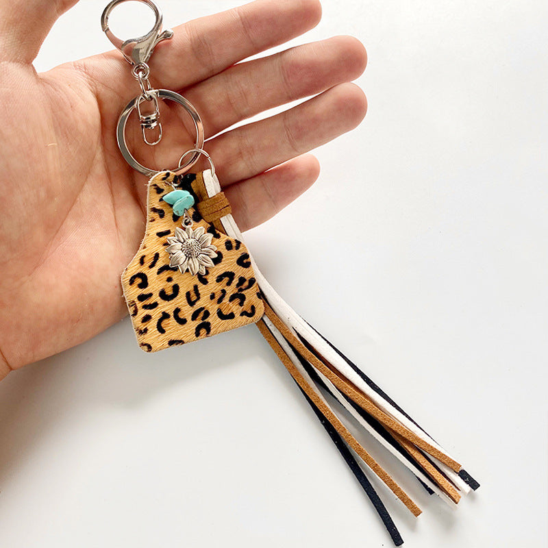 Leopard print tag keychain with sunflower charm, turquoise bead, and multi-color tassels.