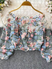 Sheer off-shoulder t-shirt with embroidered floral detail and ruffled hem.