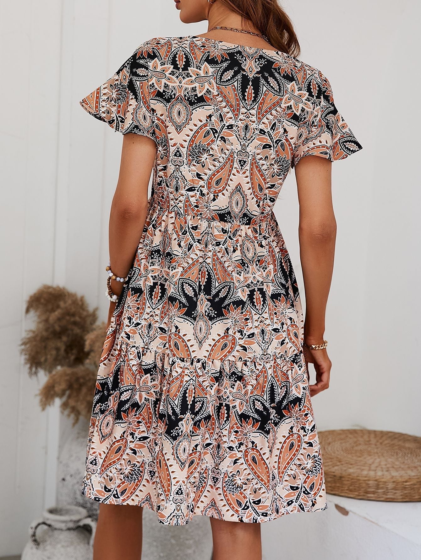 Paisley print mini dress with flutter sleeves and tiered skirt in cream and orange.