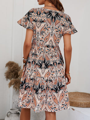 Paisley print mini dress with flutter sleeves and tiered skirt in cream and orange.