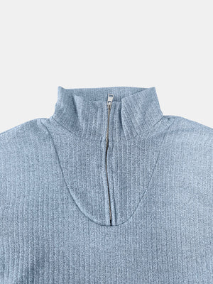 Light blue ribbed knit quarter-zip pullover sweater with a mock neck and silver zipper.
