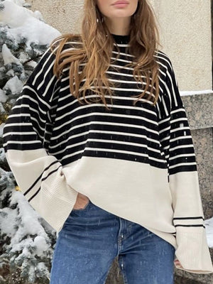 Colorblock stripe knit sweater with bell sleeves and a crew neck, styled with jeans.