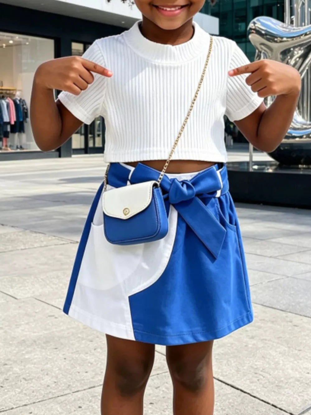 Baby knit top and skirt set with bow detail and contrast color blocking.