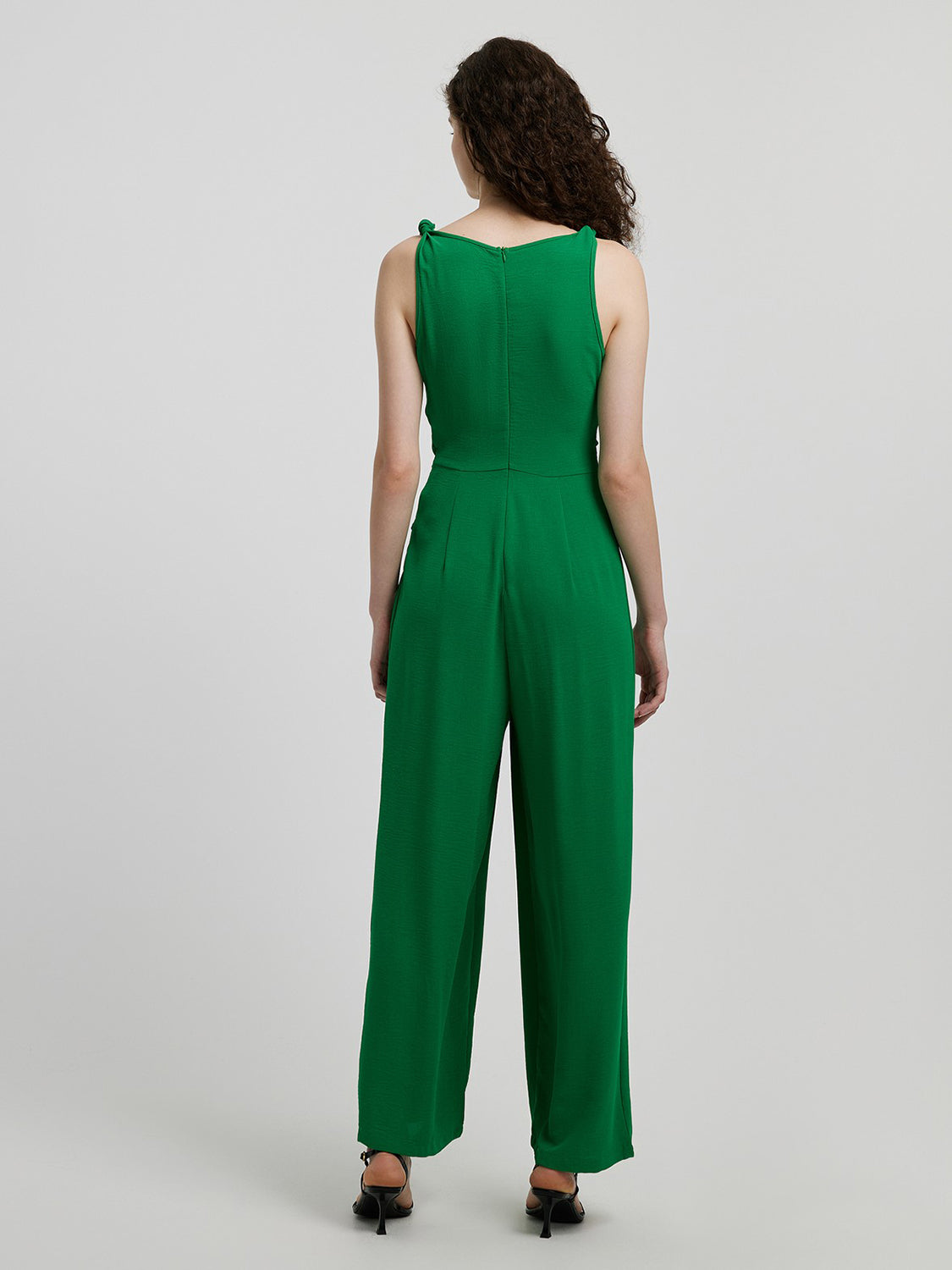 Emerald tie-waist wide leg jumpsuit in mid green with knotted shoulder straps.