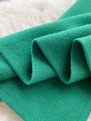 Green knit midi skirt with a subtle textured finish and a visible split detail.