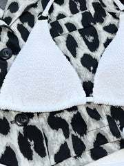 White textured bikini top with ring detail, shown with leopard print jacket.
