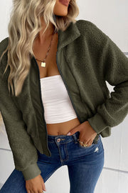 Green teddy fleece bomber jacket with collared neck and zip front, styled with jeans.