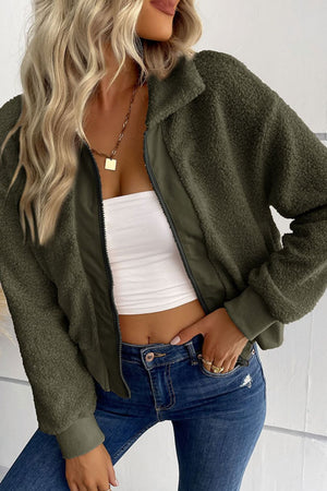 Green teddy fleece bomber jacket with collared neck and zip front, styled with jeans.