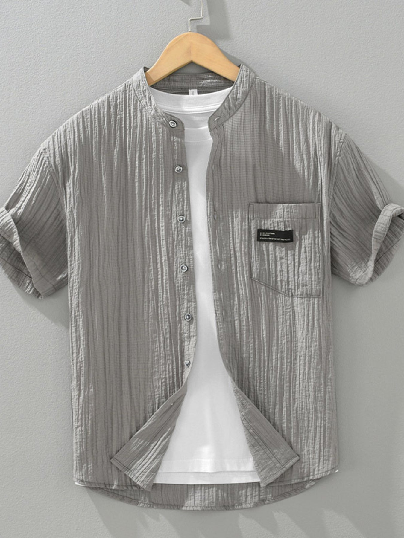 Grey textured button-up shirt with mandarin collar and chest pocket, short sleeves.