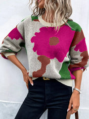 Abstract floral knit sweater with round neck in hot pink, green, and brown on a light background.
