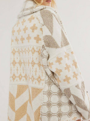 Geometric patchwork knit cardigan in cream and tan with a hooded neckline.
