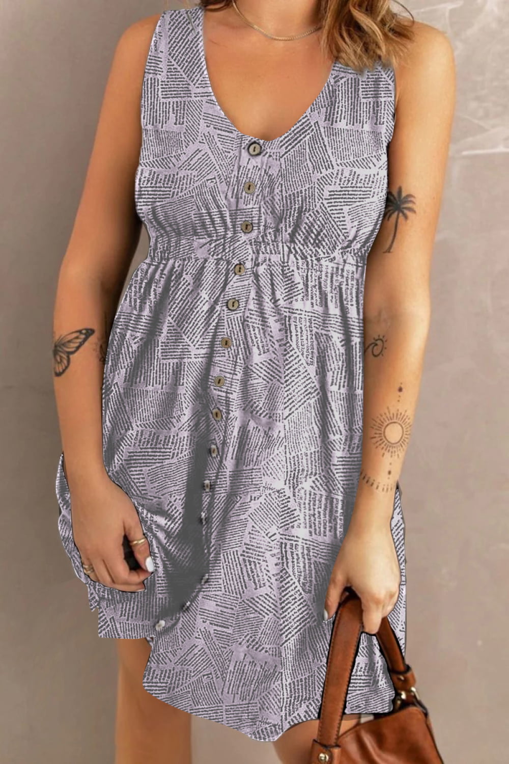 Sleeveless midi dress in light gray with a newspaper print, V-neck, button front, and elastic waist.