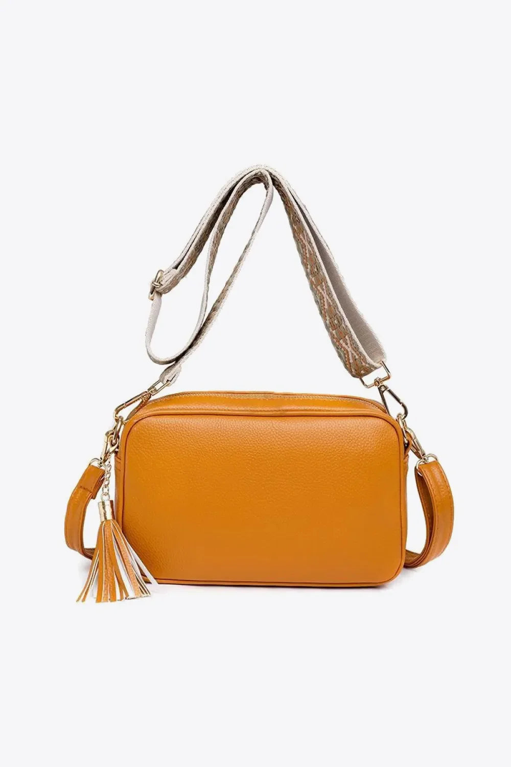 Orange textured crossbody bag with tassel detail and patterned strap