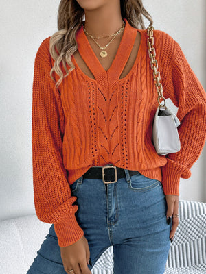 Terracotta cable knit sweater with cutout neckline and open knit detail.