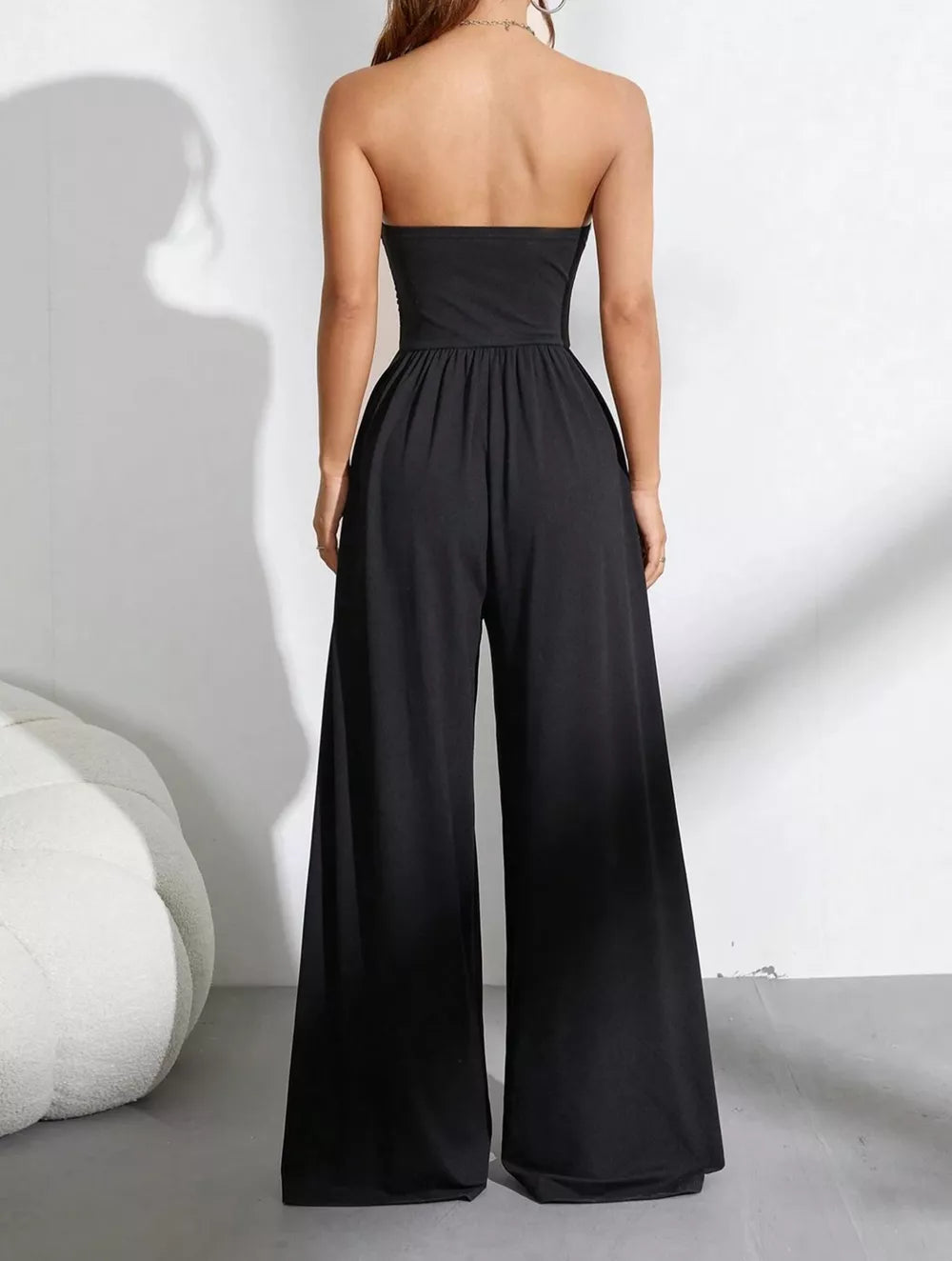 Black strapless tube top wide-leg romper with gathered waist detail.