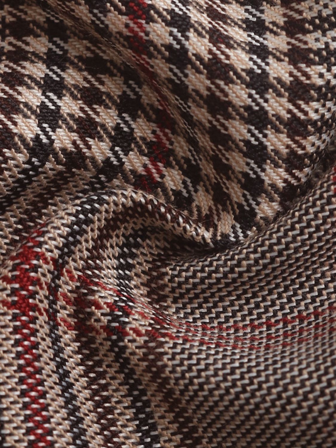 High-waisted plaid trousers in taupe with a houndstooth pattern and red accents.