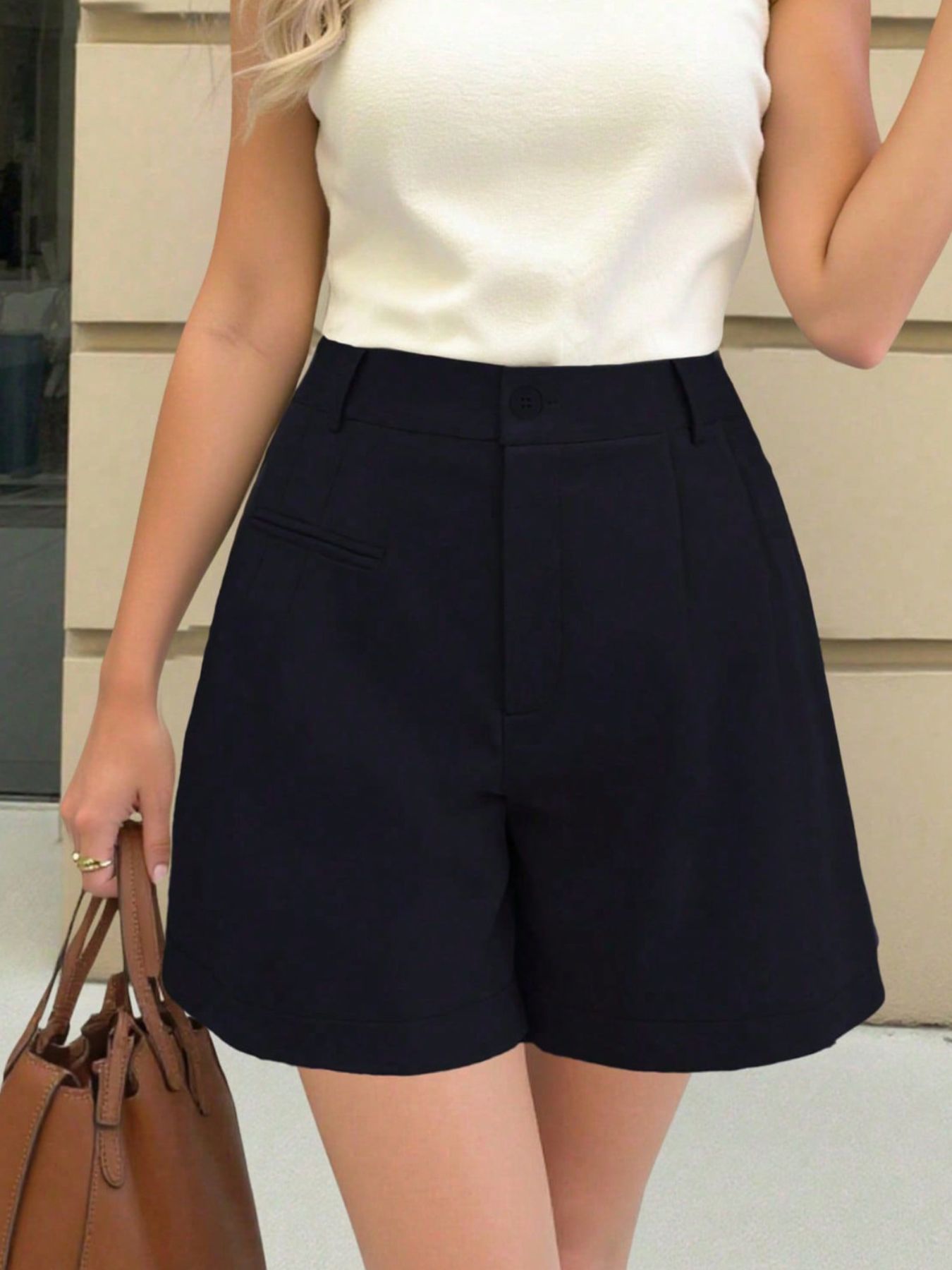 Navy blue pleated high-waisted shorts with pockets and belt loops.