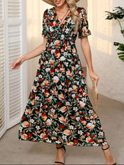 Black floral print maxi dress with V-neck, ruffled details, cinched waist, and short sleeves.