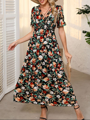 Black floral print maxi dress with V-neck, ruffled details, cinched waist, and short sleeves.