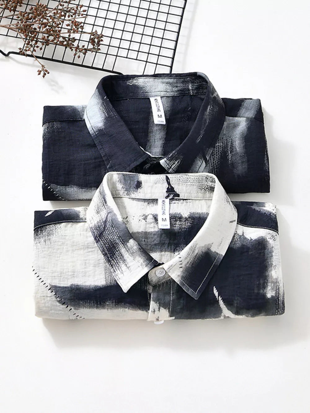 Men's abstract print button-down shirt in black and white, casual style.