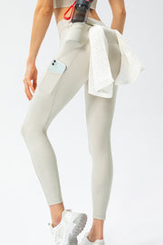 Cream athletic leggings with phone pocket and towel loop, showing back view.