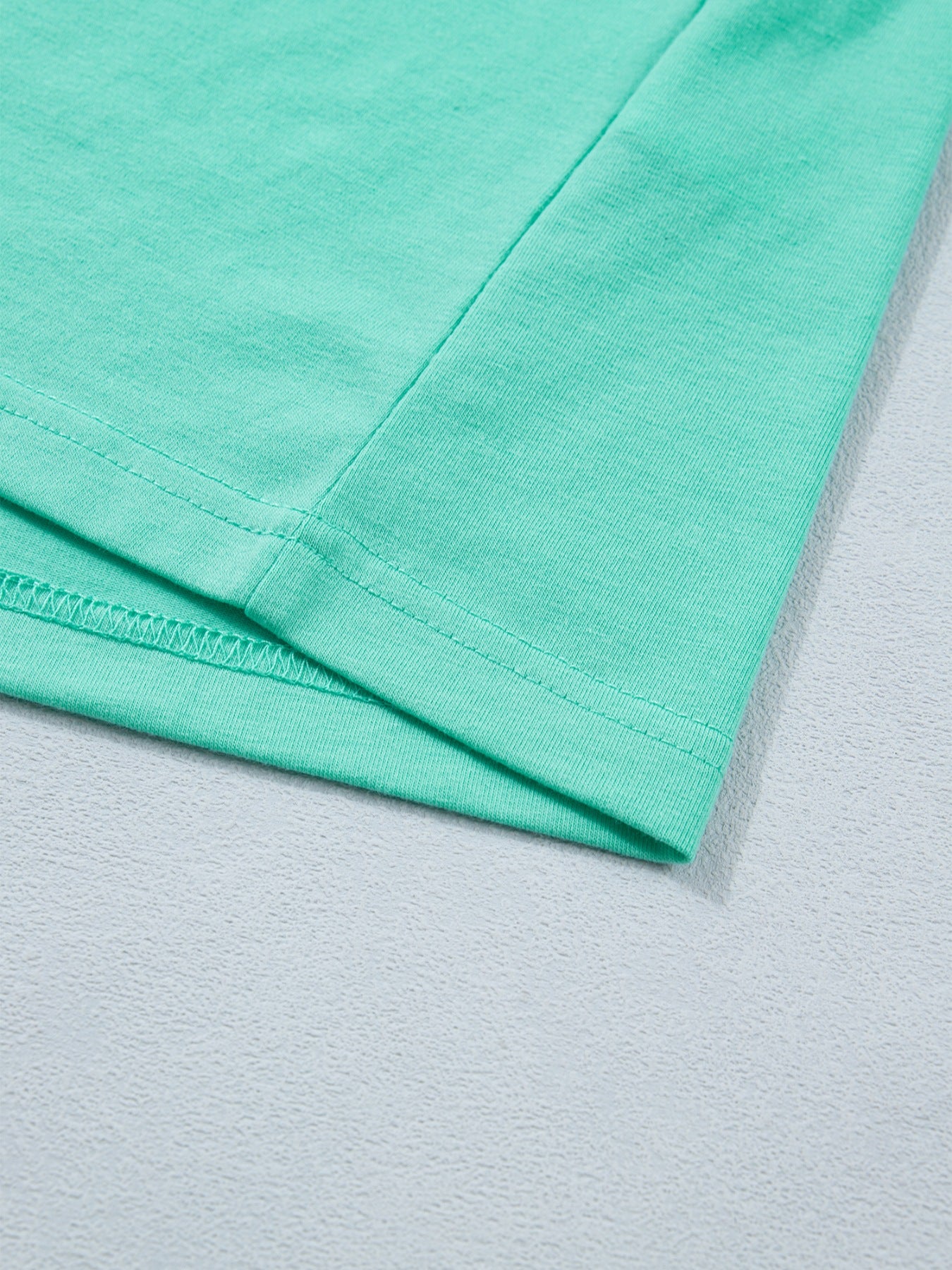 Eyelet lace ruffled cap sleeve top in mint green cotton blend fabric detail.