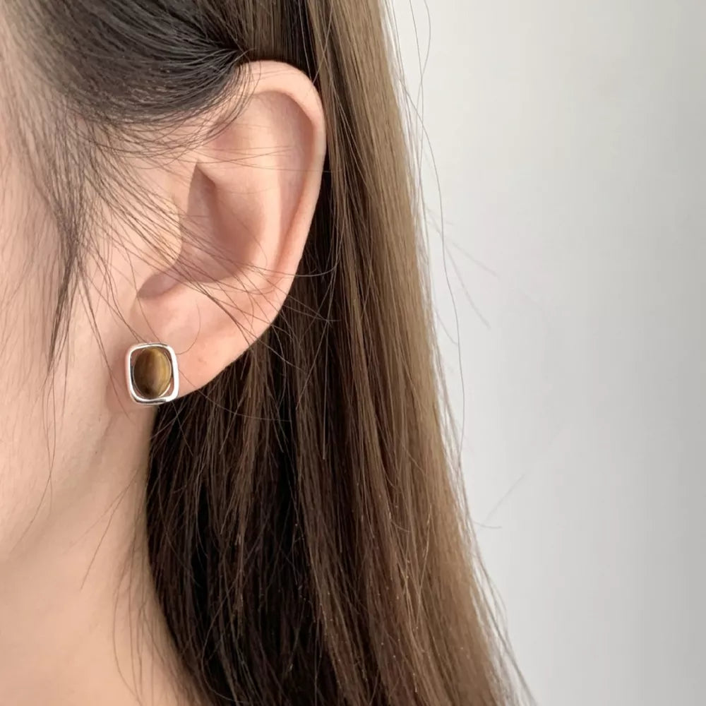 Polished tiger eye square stud earrings in silver setting.