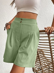 Pleated front bermuda shorts in light green with a high waist and button closure.