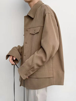Oversized khaki button-down jacket with two chest pockets and button cuffs.