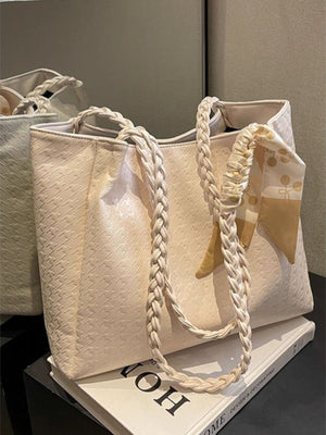 Elegant braided handle tote bag in ivory with a patterned scarf detail.