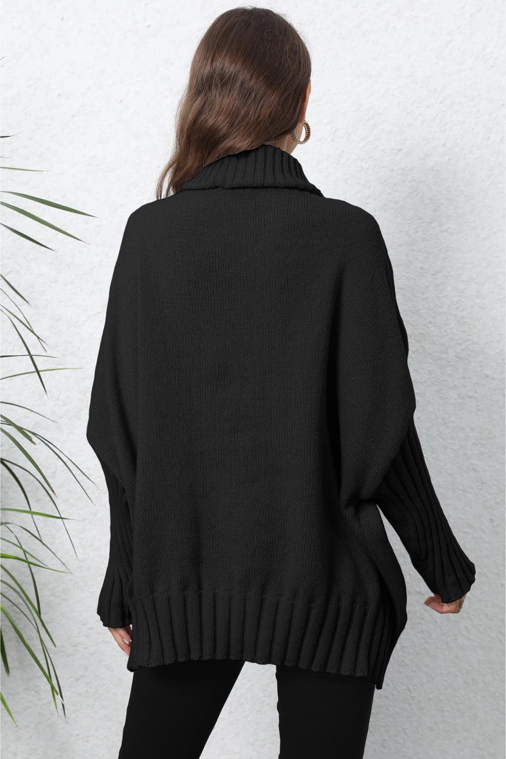 Black ribbed turtleneck sweater with batwing sleeves and cuffed hem.