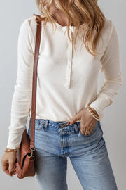 White waffle knit henley blouse with long sleeves and button detail.