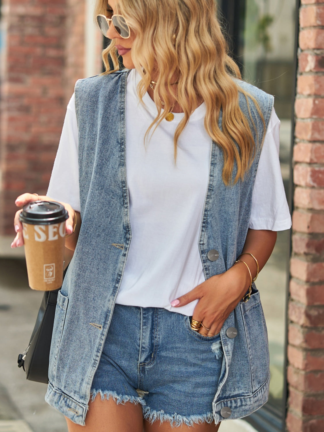 Oversized denim vest in medium wash with patch pockets and button front.